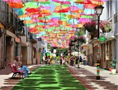 Farbenfrohe Installation: Eine Straße, überdacht von Sonnenschirmen